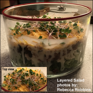 Layered Salad is comprised of broccoli, cauliflower, raisins, 8 slices bacon cooked and crumbled, sliced green onion, broken pecans, sharp cheddar cheese -- and topped with radish microgreens.